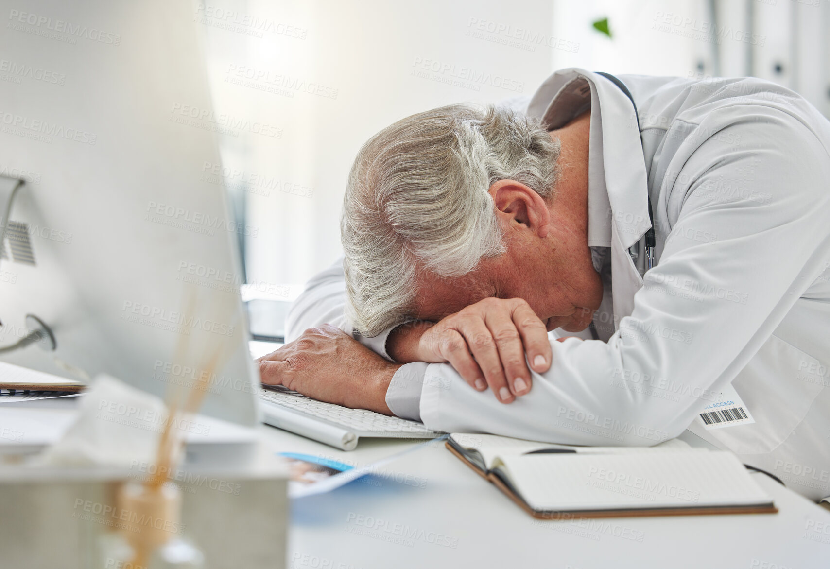 Buy stock photo Mature man, doctor and sleeping on desk from burnout, overworked or insomnia at office. Tired male medical professional, computer and nap for rest, asleep and research health solution in workplace