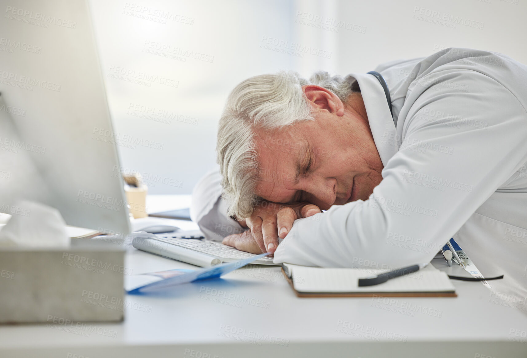 Buy stock photo Tired man, doctor and sleeping on desk from burnout, overworked or insomnia at office. Mature male medical professional, computer and nap for rest, asleep and research health solution in workplace