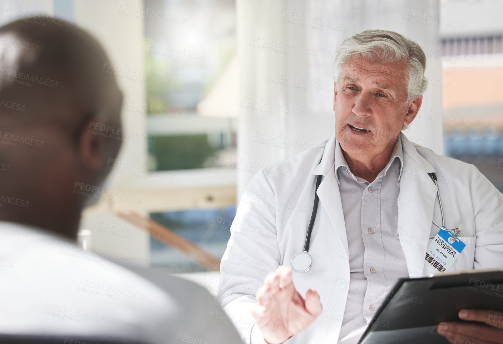 Buy stock photo Shot of a mature doctor having a checkup with a patient at a hospital