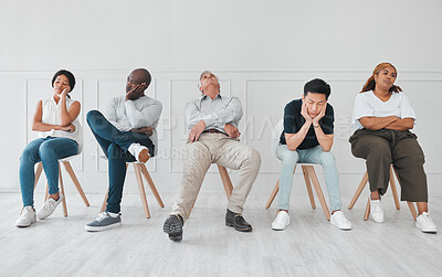 Buy stock photo Bored, job interview and diversity with business people in waiting room for tired, frustrated or fatigue. Hiring, hr and queue with employees on wall background for recruitment, onboarding or nervous