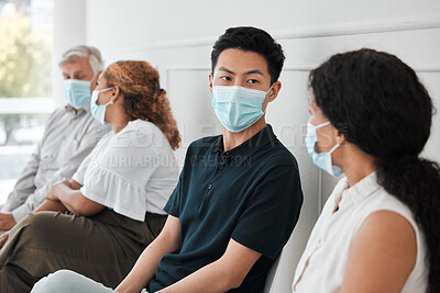 Buy stock photo Shot of a group of people wearing face masks while sitting in a queue