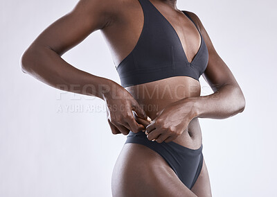 Buy stock photo Black woman, stomach and weight loss in studio for fitness, health and diet or wellness for body care. Hands, model girl and cosmetic treatment for aesthetic, glow and abs or gut by white background