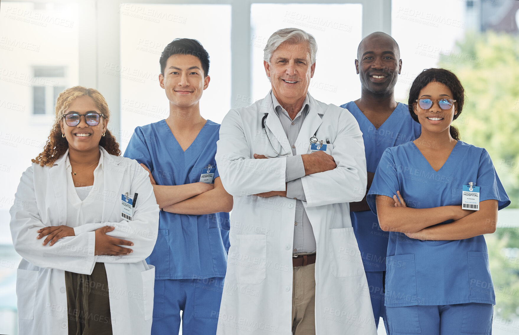 Buy stock photo Happy portrait, arms crossed and group of doctors standing together in hospital. Face, teamwork and confident medical professionals, nurses and surgeons with collaboration, healthcare and support.