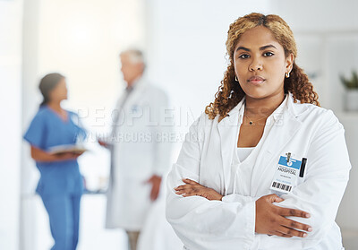 Buy stock photo Portrait of a young doctor standing with her arms crossed in a hospital