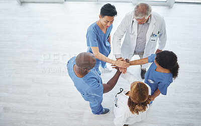 Buy stock photo High angle shot of a group of medical practitioners joining their hands together in a huddle in a hospital