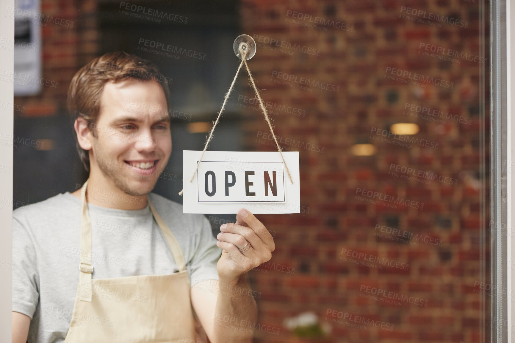 Buy stock photo Open sign, startup and small business owner in coffee shop with pride and happiness to welcome people at front door of restaurant. Happy entrepreneur ready for service at cafe or retail store