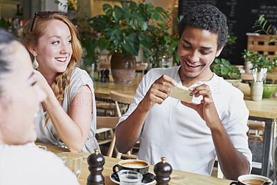 Buy stock photo Phone, photograph and black man with a friends in a coffee shop for a social gathering or bonding. Social media, cafe and mobile with a happy male and group sitting together in a cafe for lunch