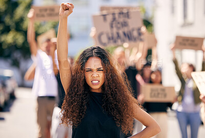 Buy stock photo Shot of a young female protestor at a rally with her fist raised