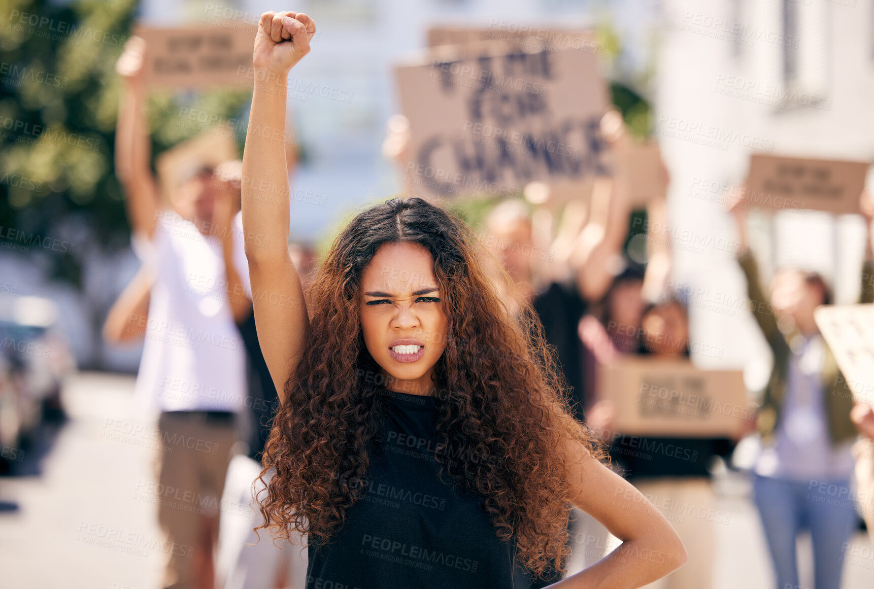 Buy stock photo Shot of a young female protestor at a rally with her fist raised