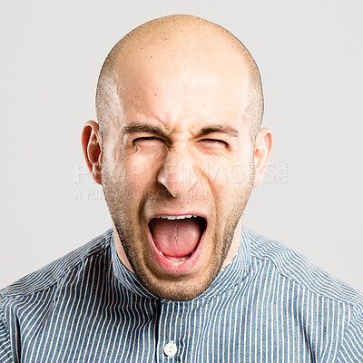 Buy stock photo Shot of a handsome young man standing alone in the studio and screaming