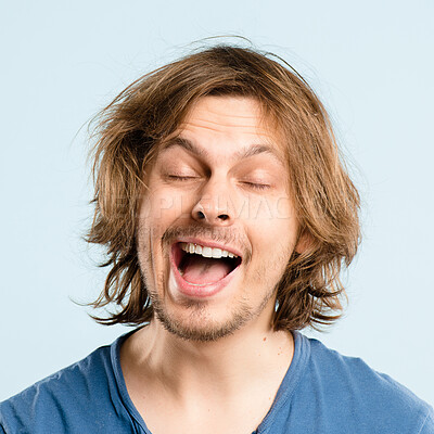 Buy stock photo Man, happy and playful face for joke, character and relax with positive mood, funny and blue background. Male person, mouth and silly facial expression for comedy and quirky personality in studio
