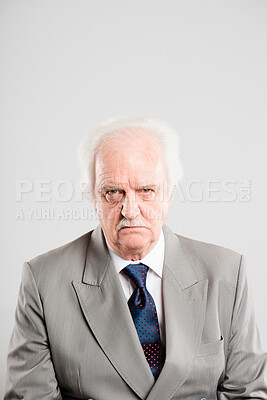 Buy stock photo Shot of a senior man sitting alone in the studio and looking grumpy