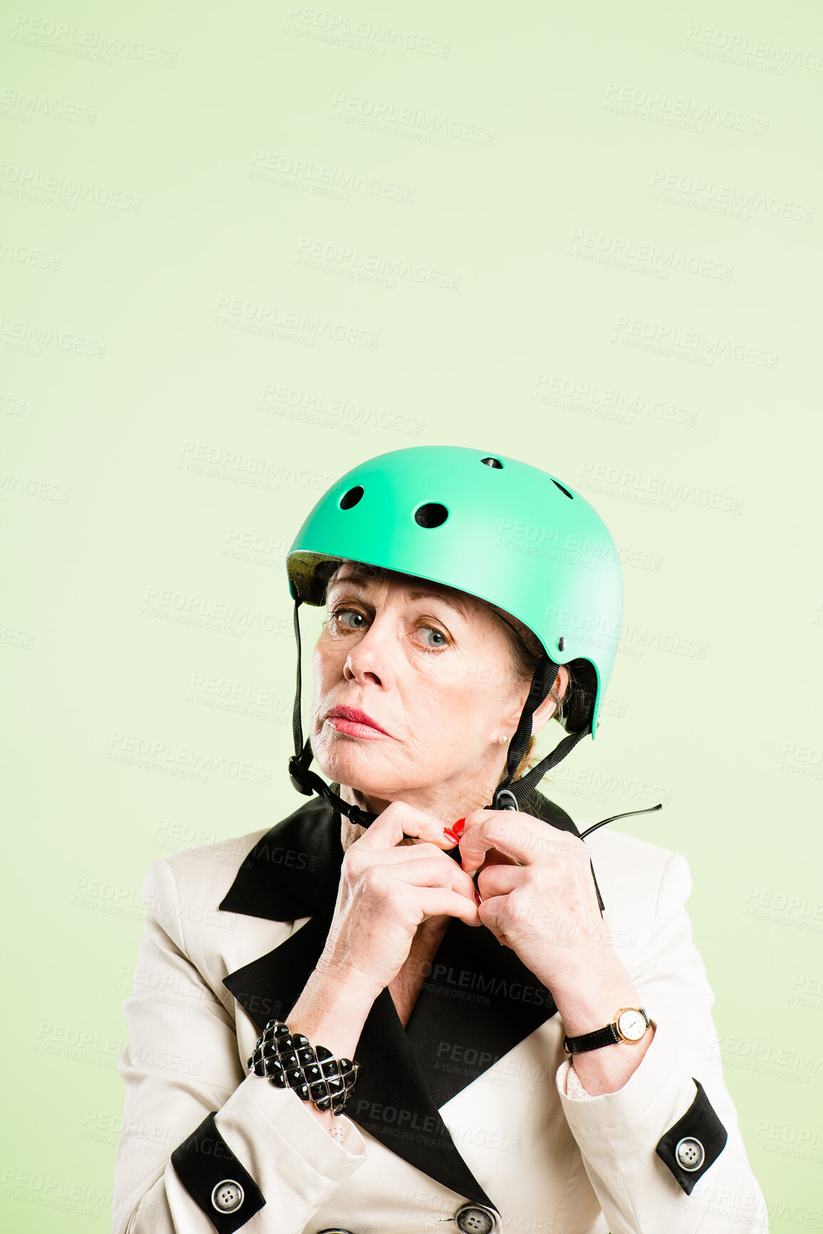 Buy stock photo Shot of a senior woman sitting alone in the studio and putting a helmet on