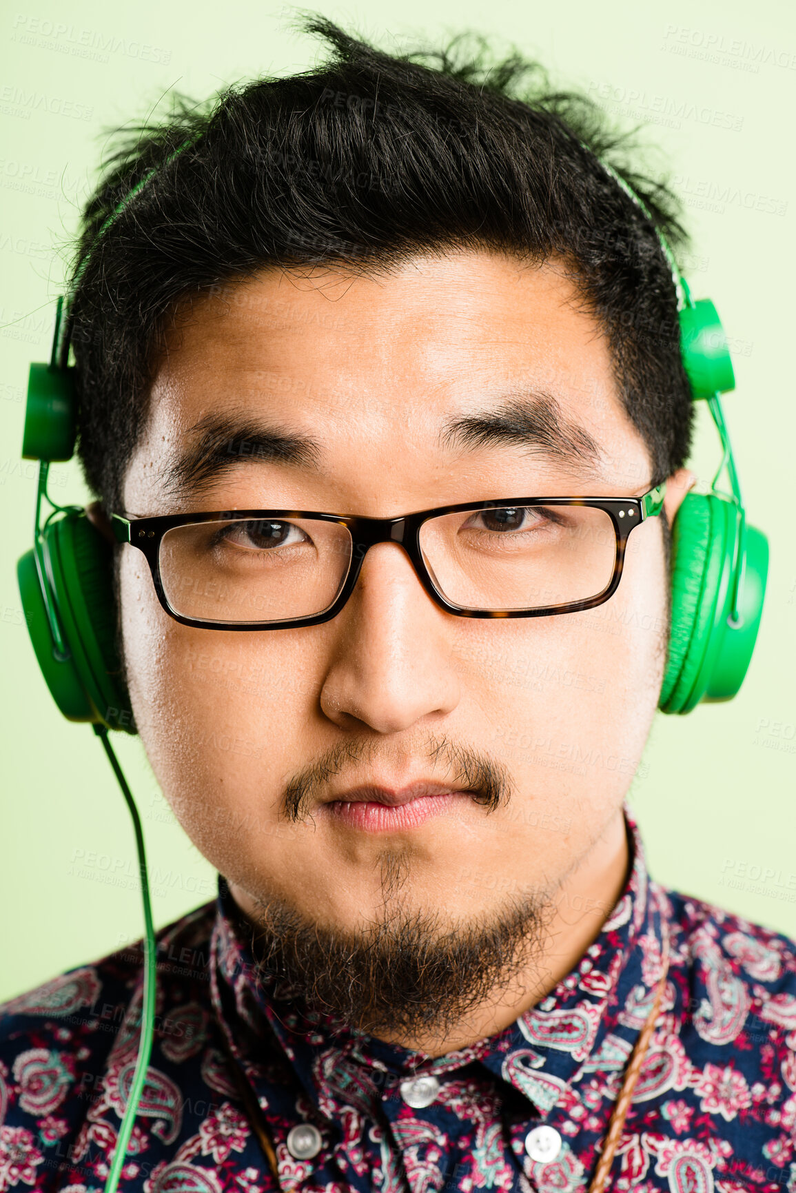 Buy stock photo Headphones, relax and portrait of Asian man in studio listening to audio, streaming song and radio. Mockup, podcast and face of person for entertainment, subscription or chill on green background