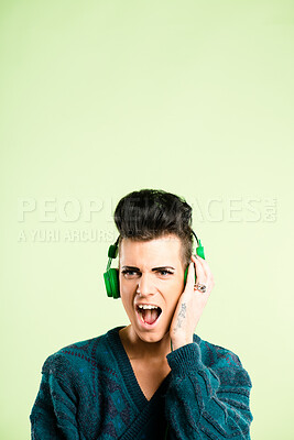 Buy stock photo Shock, music and man with headphones in studio listen to audio, streaming podcast and radio. Mockup space, surprise and face of person for entertainment, relax and subscription on green background