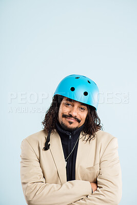 Buy stock photo Shot of a handsome young man standing alone in the studio with his arms folded while wearing a helmet