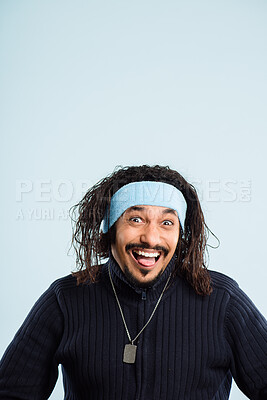 Buy stock photo Shot of a handsome young man standing alone in the studio and pulling a funny face