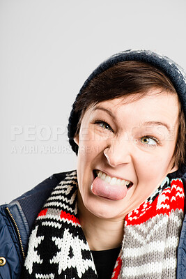 Buy stock photo Shot of an attractive young woman standing alone in the studio and pulling funny faces