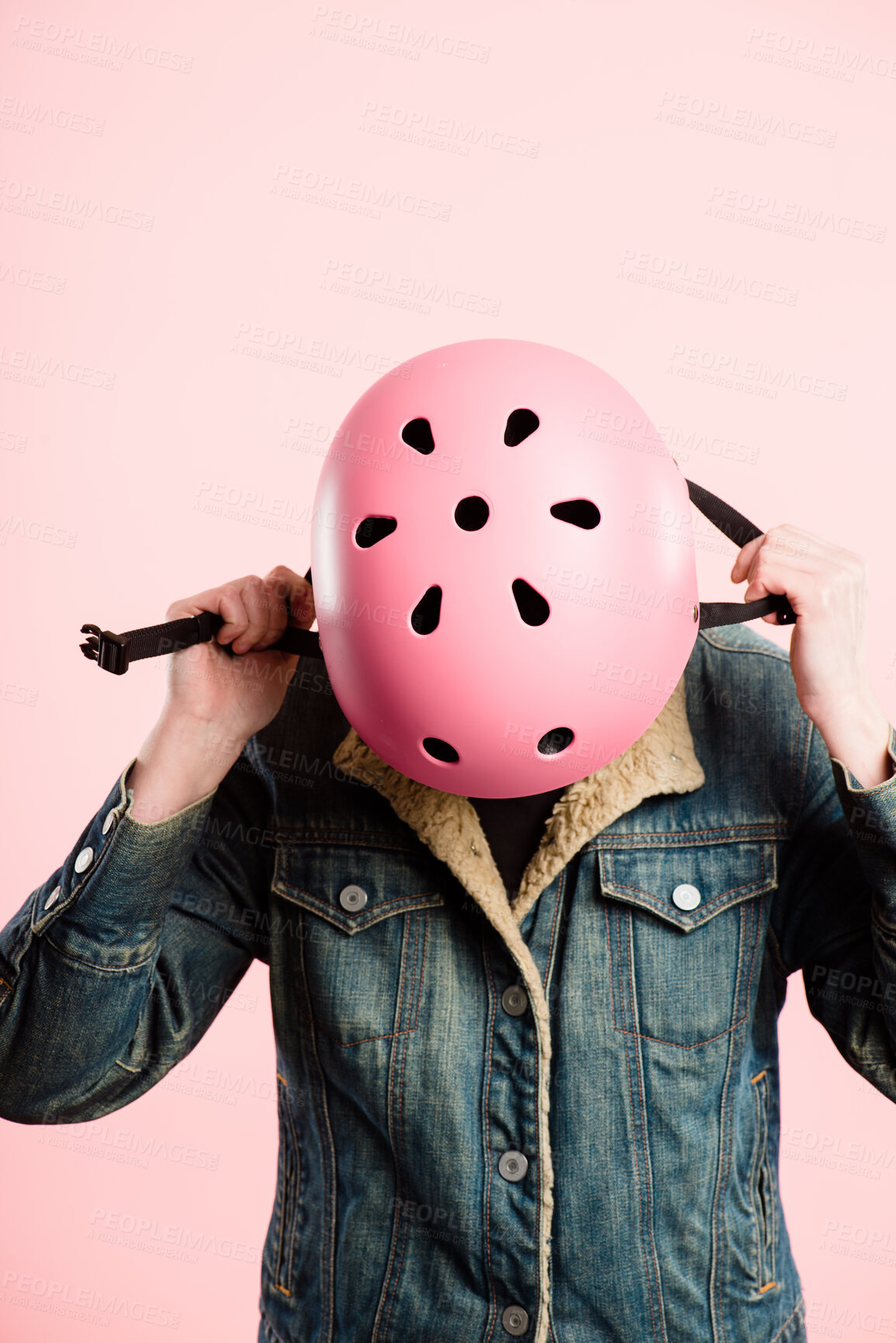 Buy stock photo Bicycle helmet, safety or hands of person in studio for protection, fashion or aesthetic. Rider, hard hat or looking down on pink background for travel, designer clothes or ready for journey on bike