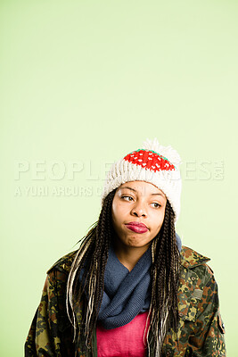 Buy stock photo Shot of an attractive young woman sitting alone in the studio and looking bored