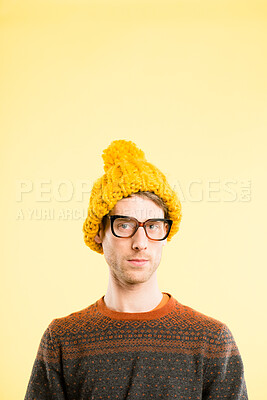 Buy stock photo Shot of a handsome young man standing alone in the studio and posing while wearing a beanie and glasses