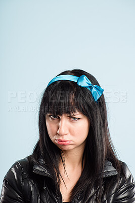 Buy stock photo Shot of an attractive young woman standing alone in the studio and sulking