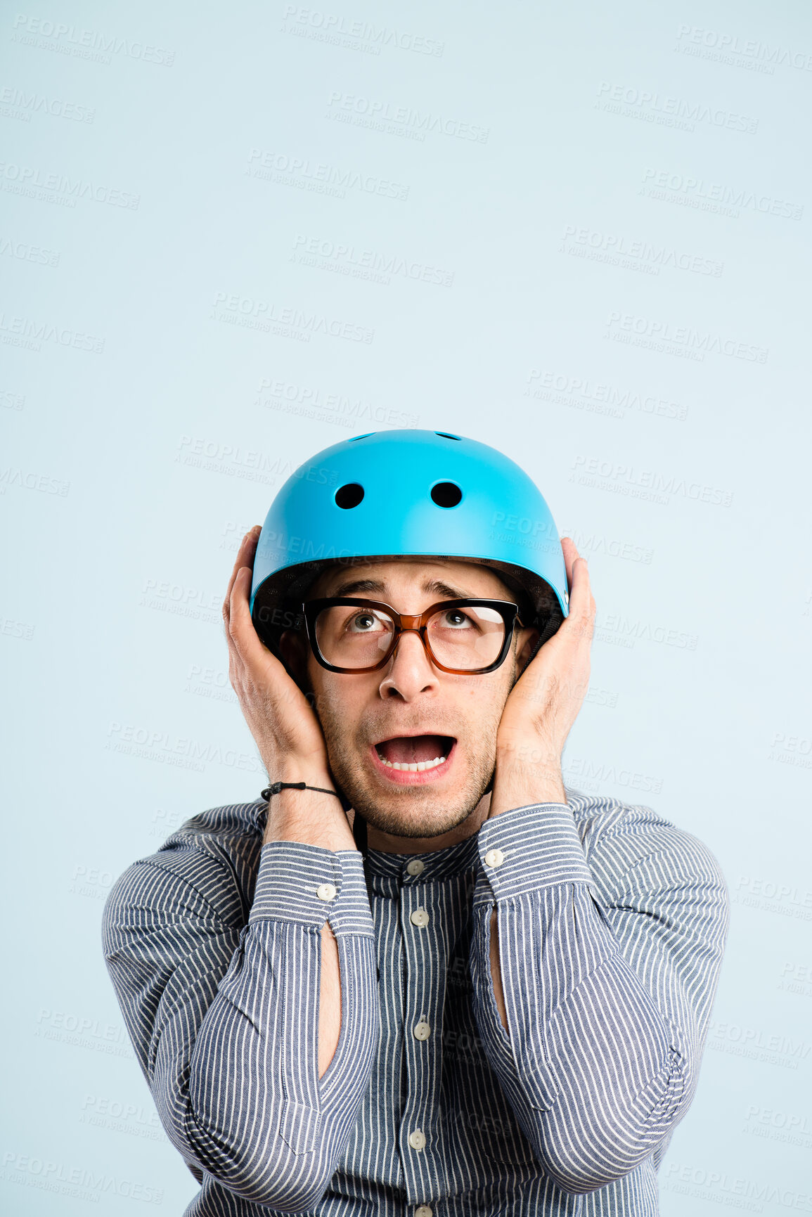 Buy stock photo Shout, scared and businessman with helmet in studio with mockup space to commute to work. Crazy, fear and male corporate employee with safety equipment for travel cycling by blue background.