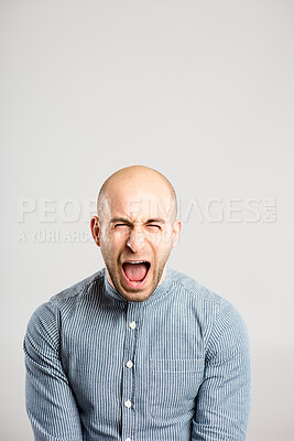 Buy stock photo Shot of a handsome young man standing alone in the studio and screaming
