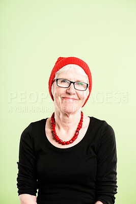 Buy stock photo Shot of a senior woman sitting alone in the studio and posing while wearing a beanie