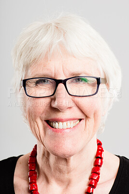 Buy stock photo Shot of a senior woman standing alone in the studio and posing while wearing glasses