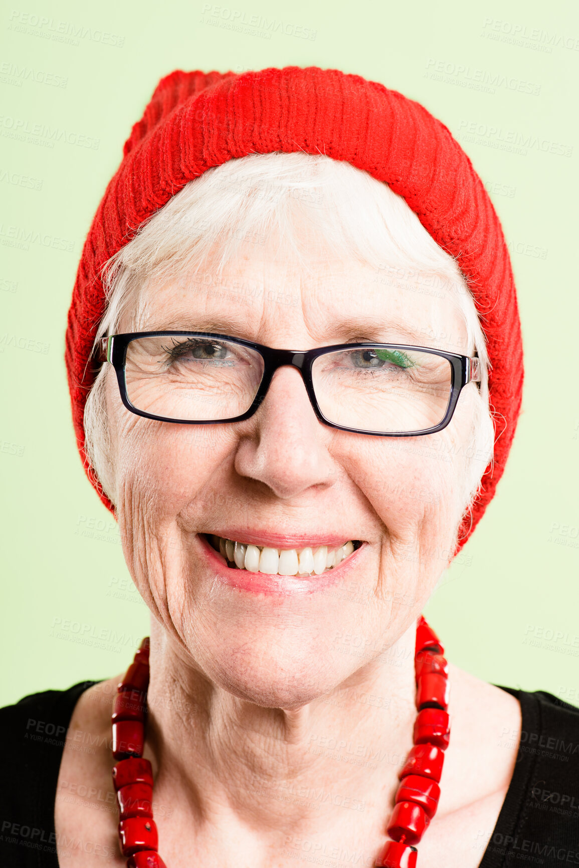 Buy stock photo Shot of a senior woman standing alone in the studio and posing while wearing a beanie and glasses