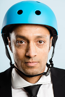 Buy stock photo Shot of a handsome young businessman standing alone in the studio and posing while wearing a helmet