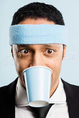 Buy stock photo Shot of a handsome young man standing alone in the studio and biting a coffee cup
