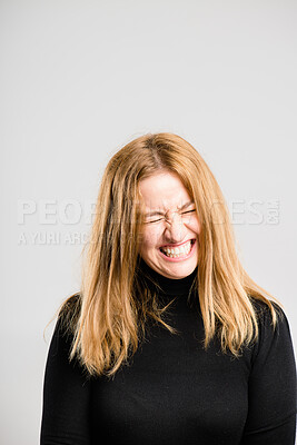 Buy stock photo Shot of an attractive young woman standing alone in the studio and laughing