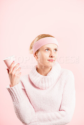 Buy stock photo Shot of a young woman standing in the studio and posing while wearing a headband and holding a coffee cup