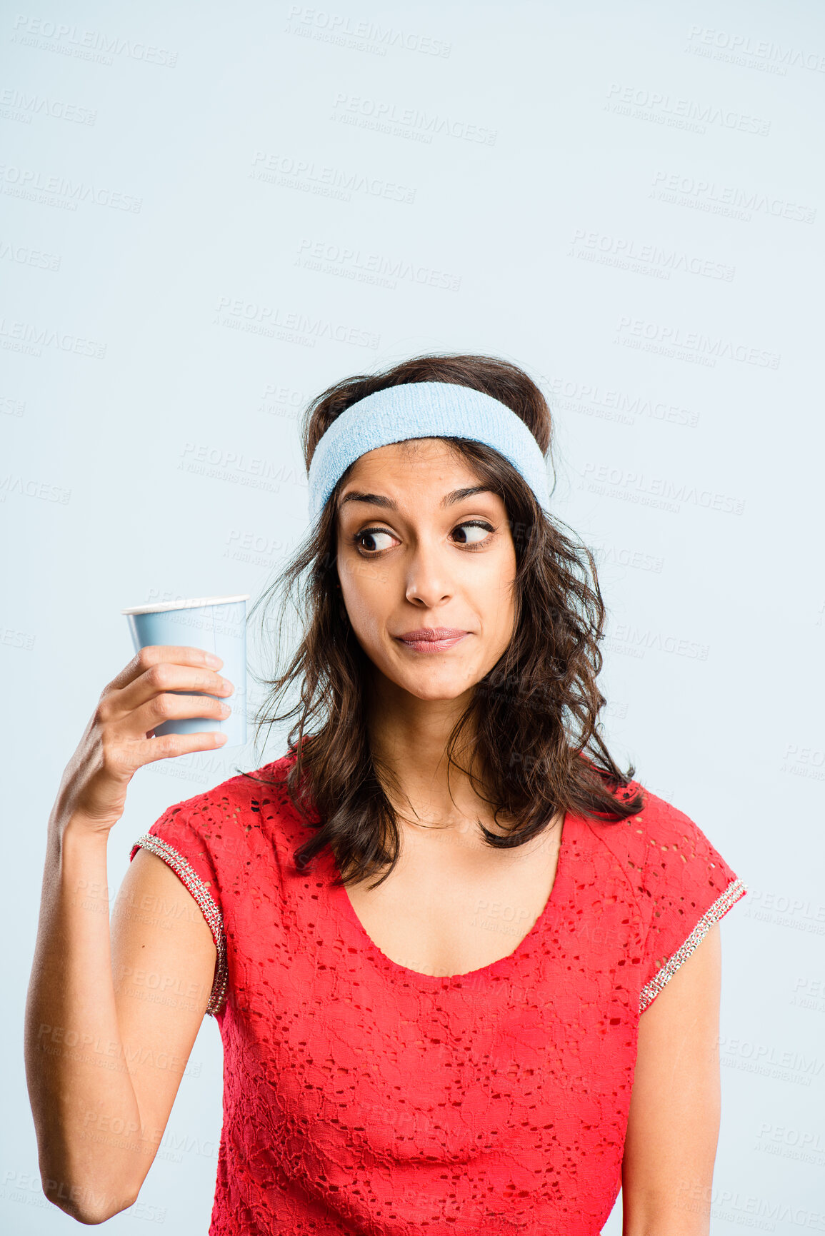 Buy stock photo Shot of a young woman standing in the studio and posing while wearing a headband and holding a coffee cup