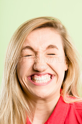 Buy stock photo Happy woman, funny face and teeth with goofy expression for humor or comedy in studio on a green background. Closeup, female person or silly model with big smile and eyes closed for comic or fun joke