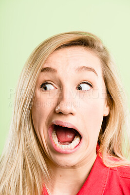 Buy stock photo Woman, surprise and funny face with goofy expression for humor or comedy in studio on a green background. Closeup, female person or silly model in shock with open mouth for comedian comic or fun joke