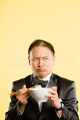 Buy stock photo Man, chopsticks and thinking in studio with funny face, tuxedo and confused with bowl by background. Chinese person, container and comic for nutrition, eating or diet choice in suit with mockup space