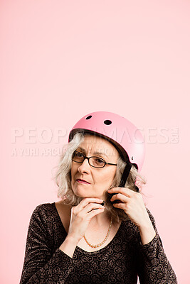 Buy stock photo Glasses, helmet and thinking with senior woman in studio isolated on pink background for cycling. Eyewear, face and safety with old person getting ready on mockup space for fashion, fitness or vision