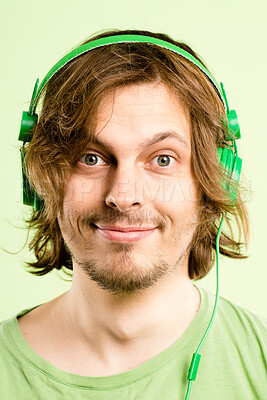 Buy stock photo Headphones, happy and portrait of man on green background listen to audio, streaming song and radio. Relax, subscription and face of person with tech for entertainment, music or chill in studio