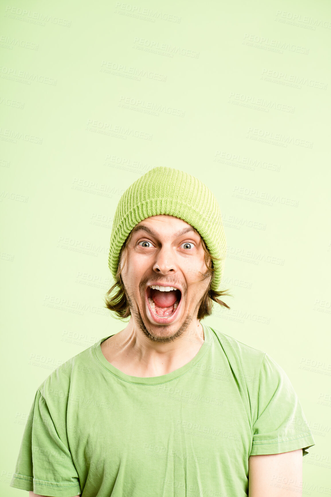 Buy stock photo Shouting, screaming and portrait of man on green background with anger, upset and crazy reaction. Body language, facial expression and isolated person with loud noise, voice and comic in studio