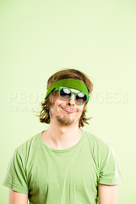 Buy stock photo Shot of a handsome young man standing alone in the studio and looking bored while wearing a headband