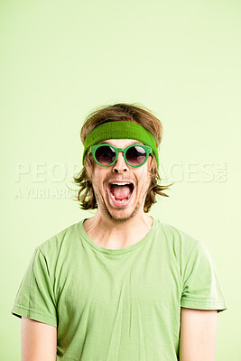 Buy stock photo Shot of a handsome young man standing alone in the studio and looking excited while wearing a headband