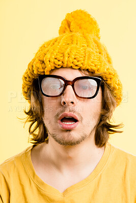 Buy stock photo Shot of a handsome young man standing alone in the studio and looking dazed while wearing foggy glasses