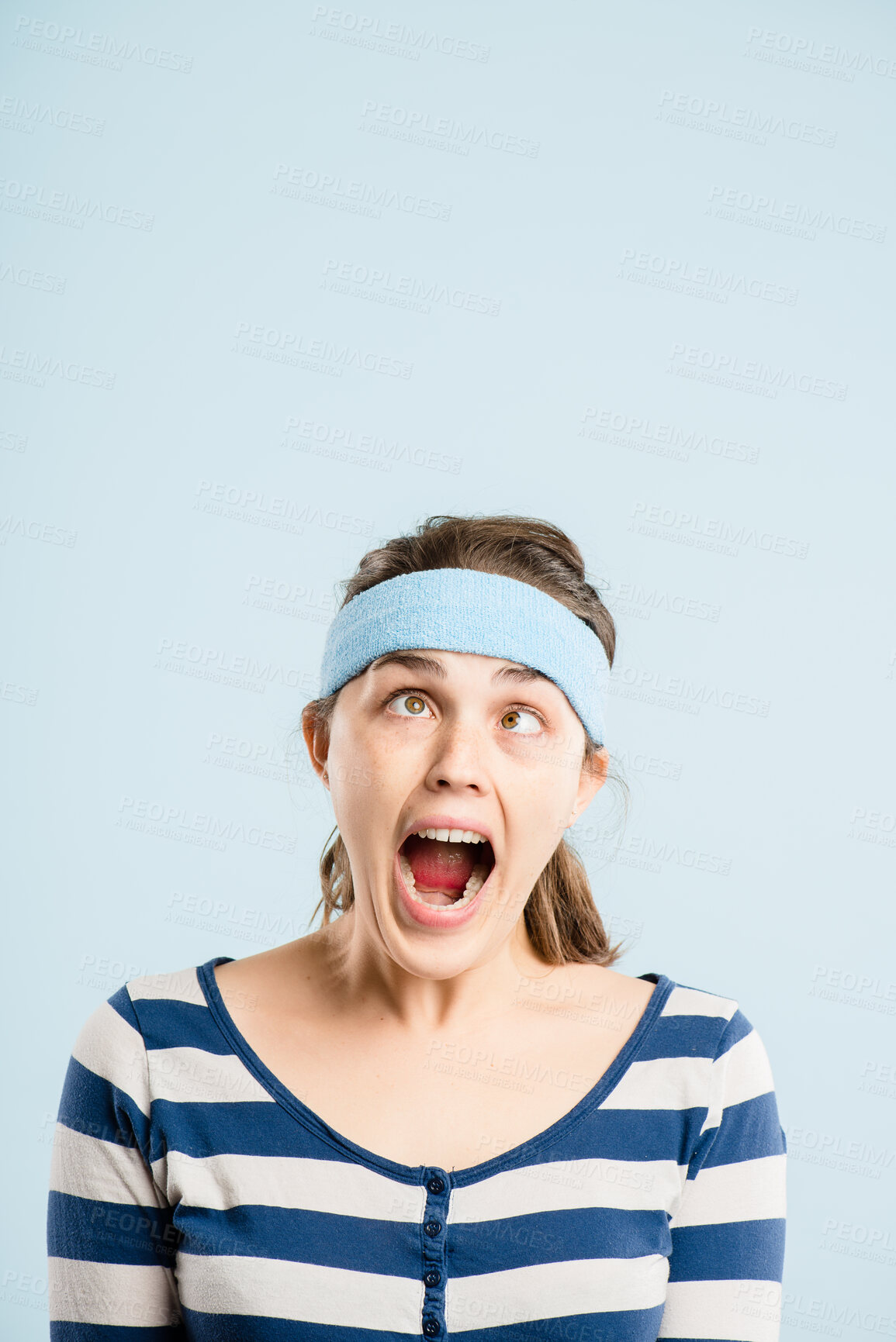 Buy stock photo Woman, funny face and scream with headband, retro fashion and comedy with mockup in studio. Promotion, cross eyes and joke with hipster, crazy emoji expression and accessory with blue background