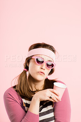 Buy stock photo Shot of an young woman standing in the studio and posing while wearing a headband and holding a coffee cup