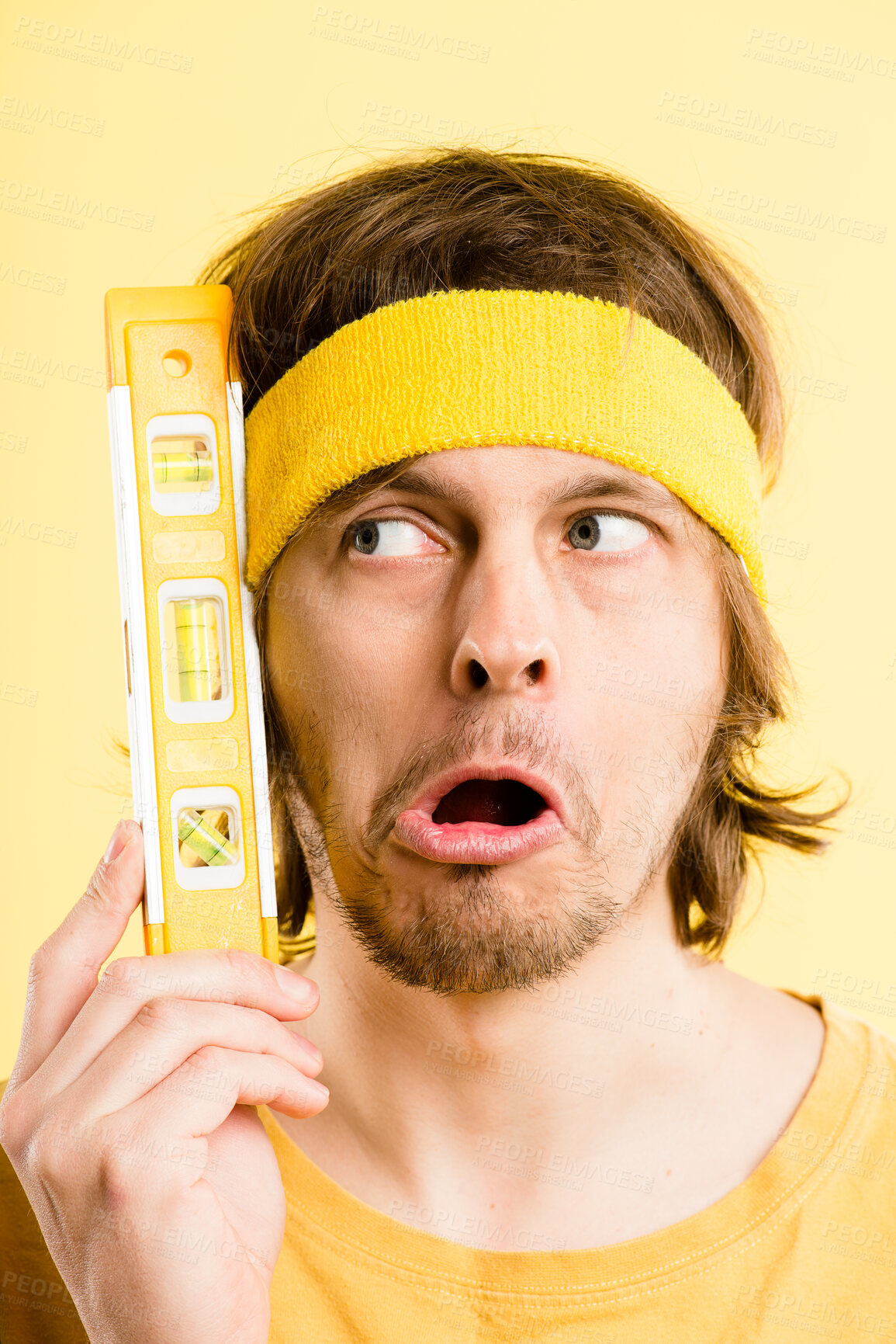 Buy stock photo Thinking, goofy and face of man in studio with funny, comic and facial expression with water level tool. Thoughtful, comedy and crazy male model with silly personality isolated on yellow background