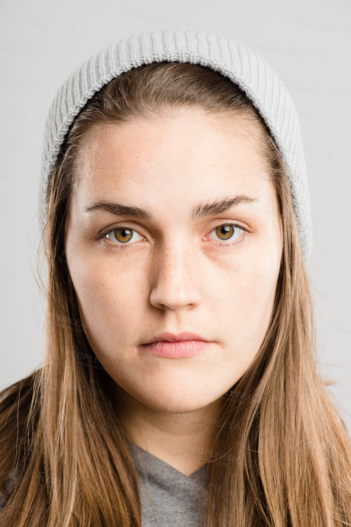 Buy stock photo Portrait, woman and serious with beanie for fashion in studio, winter weather and warm clothes in morning. Pensive, female person and knitted hat for stylish aesthetic, trendy and white background

