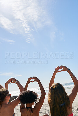 Buy stock photo Relax, hands in heart and friends at beach for summer holiday, tropical vacation and weekend outdoors. Mockup space, blue sky and back of women by ocean with emoji, love sign and gesture for travel